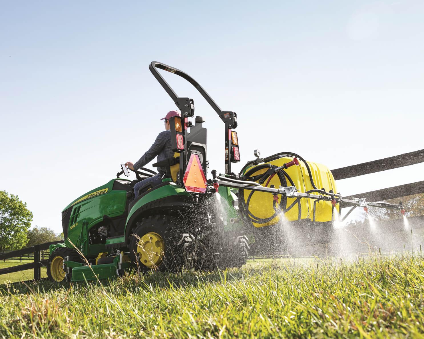 A John Deere 1025R with a sprayer attachments sprays for pests in Tennessee.