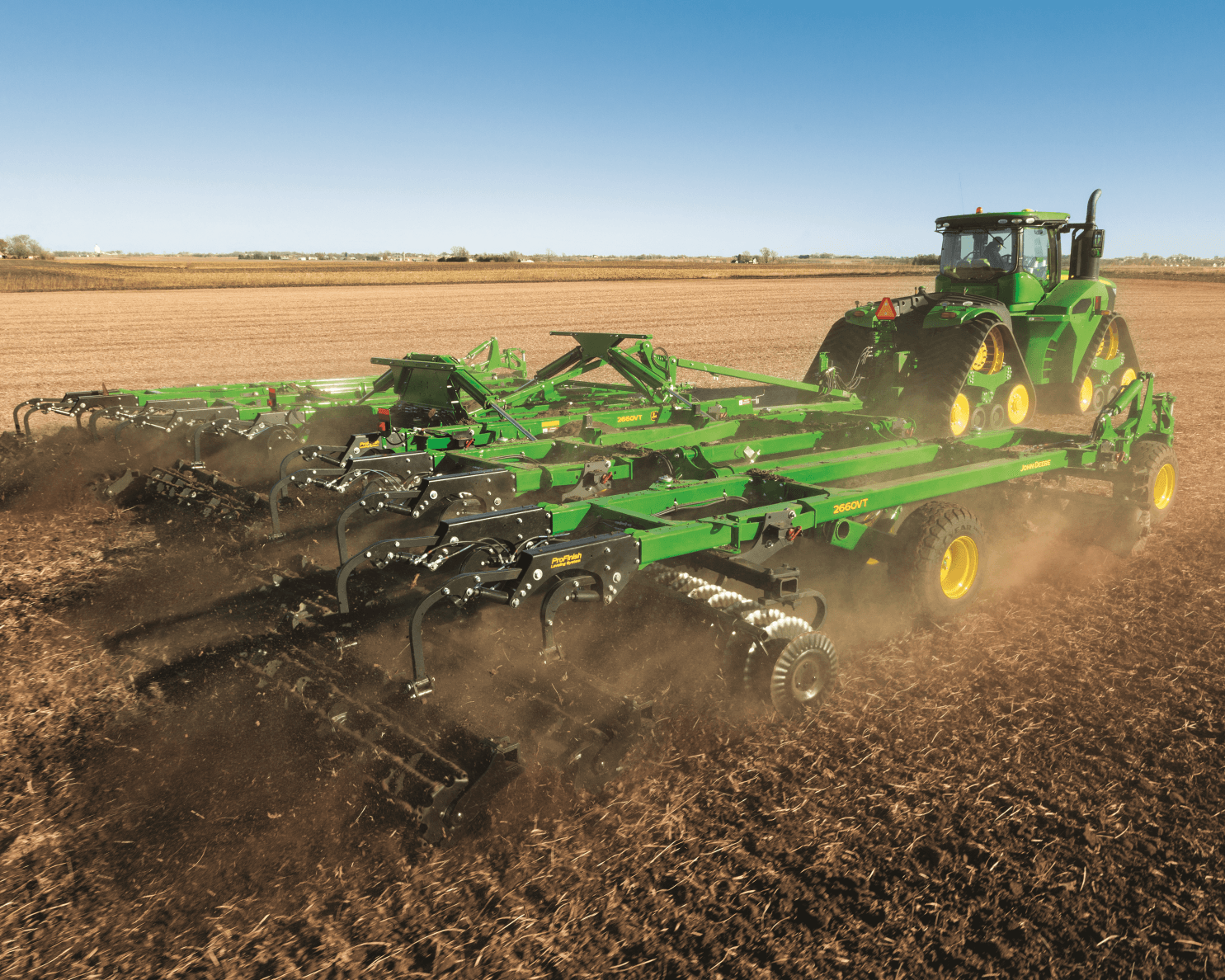 John Deere tiller tilling a field.