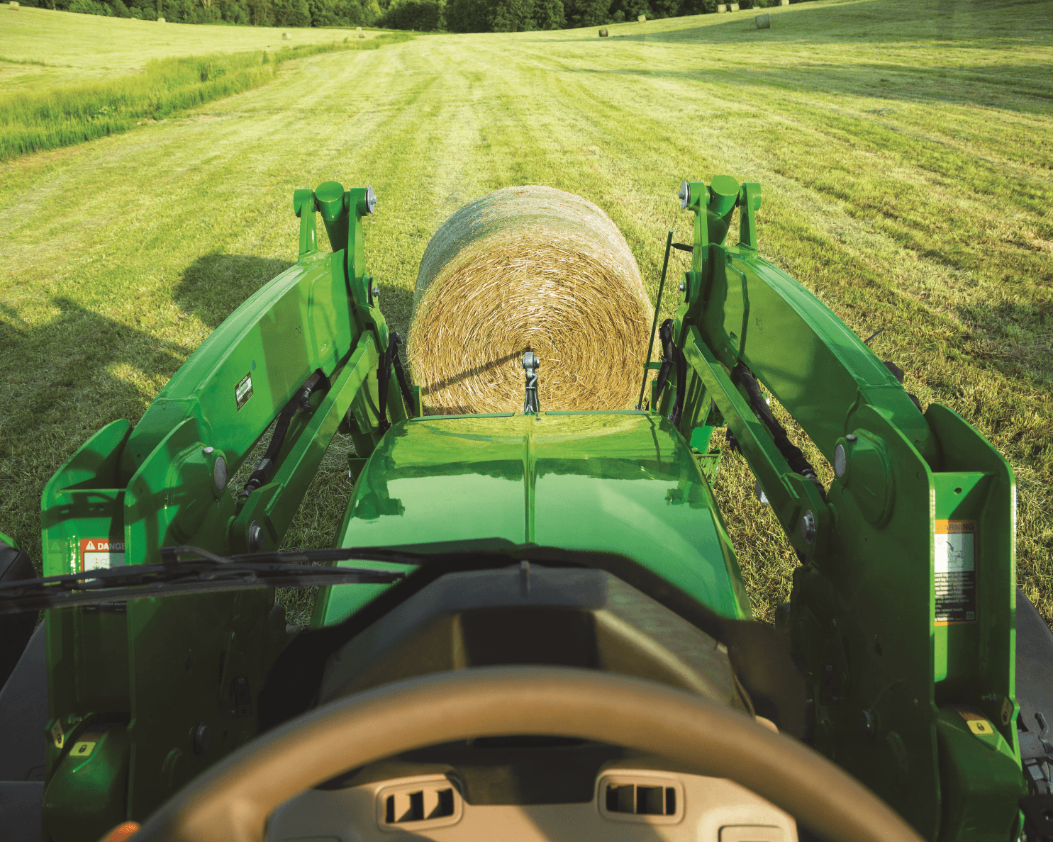 A first person point of view driving a John Deere 6120M tractor.