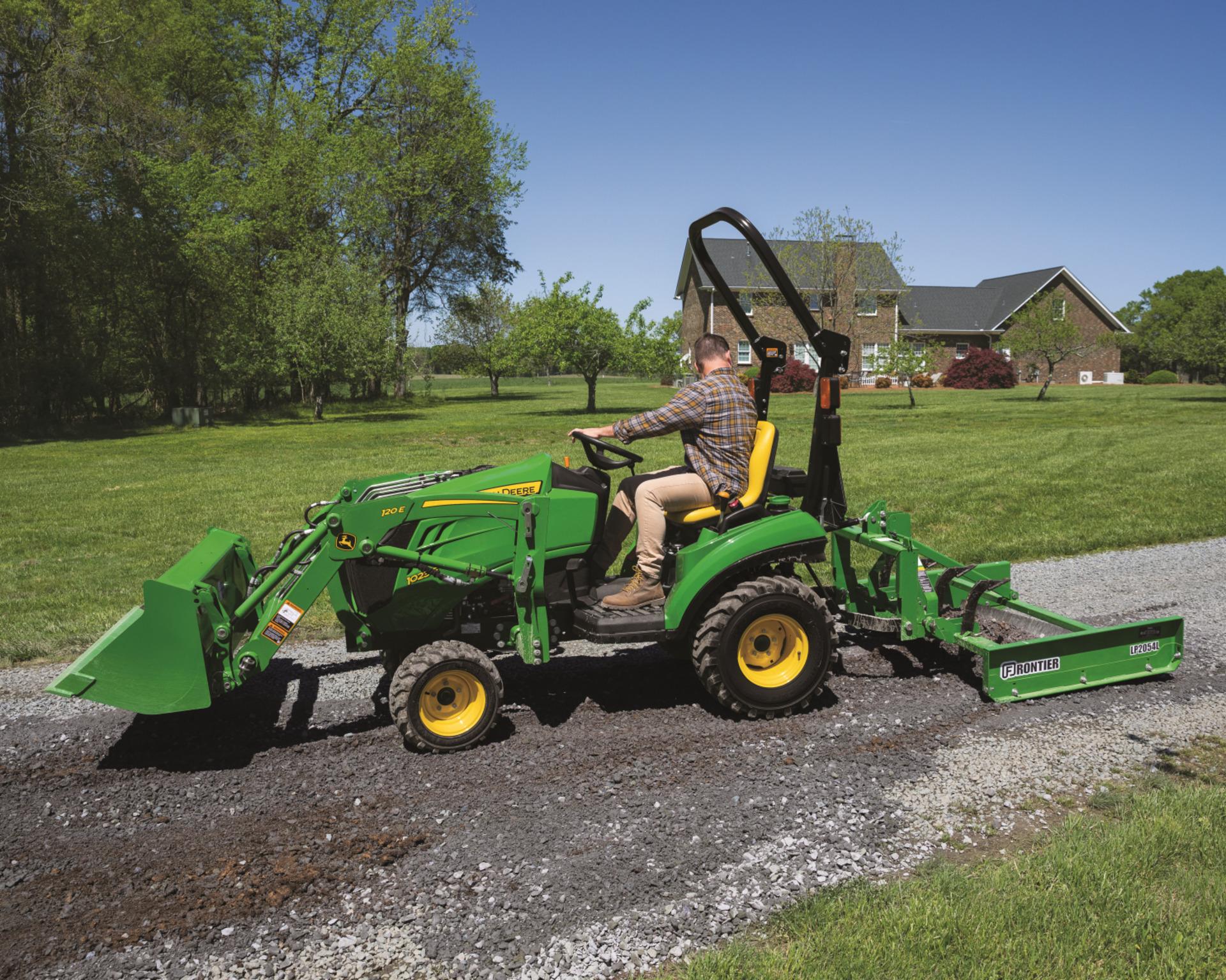 A John Deere 1023E grating gravel on a property in Tennessee.