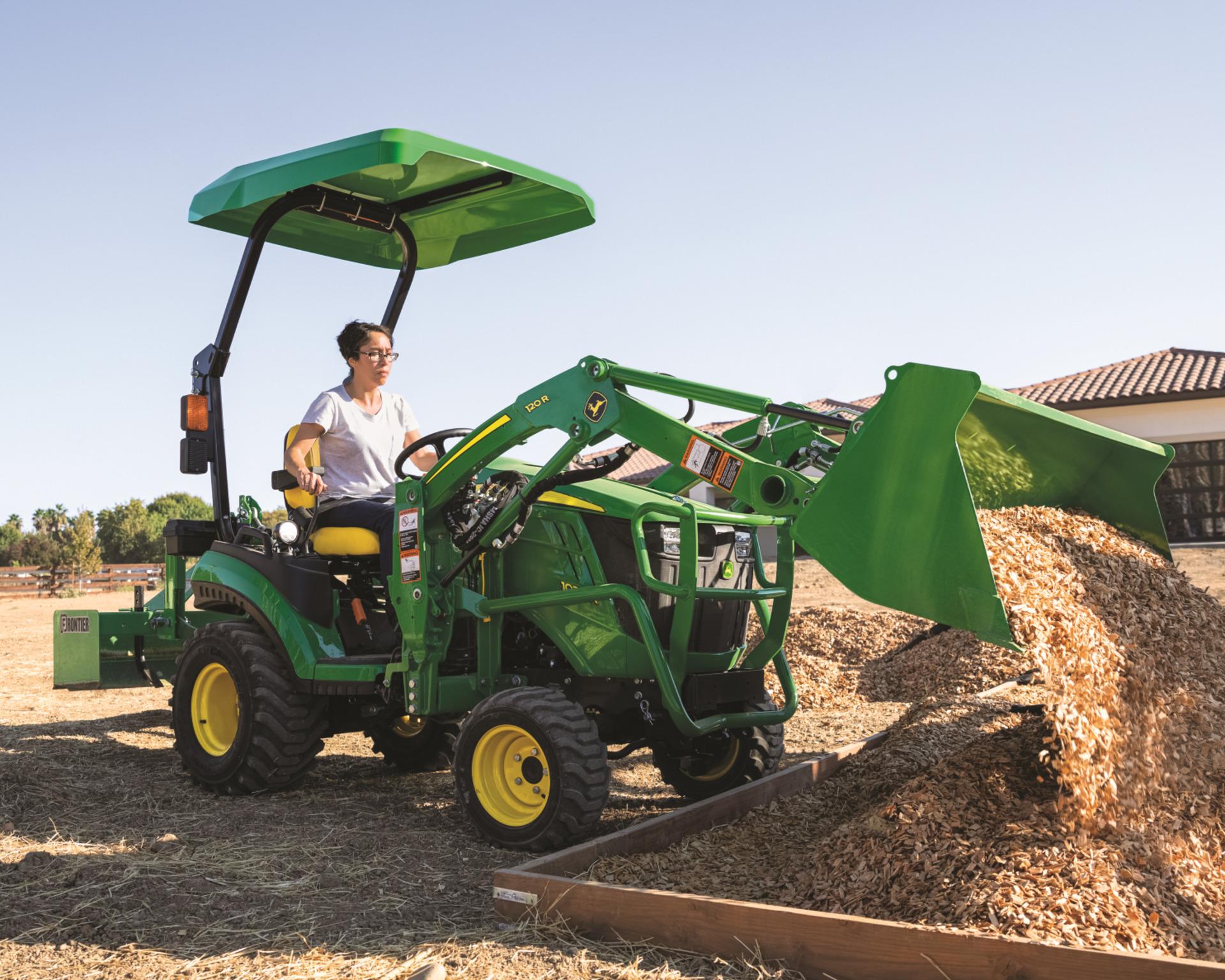 A John Deere compact utility tractor with a 120R Loader attachment.