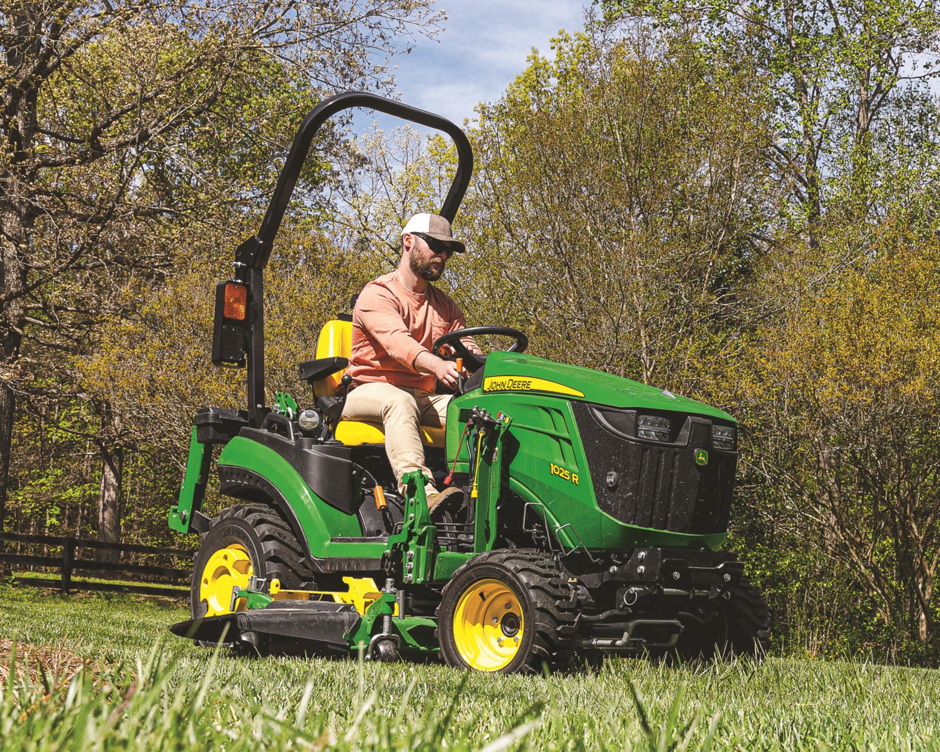 A John Deere mid-mower deck on a compact utility tractor.