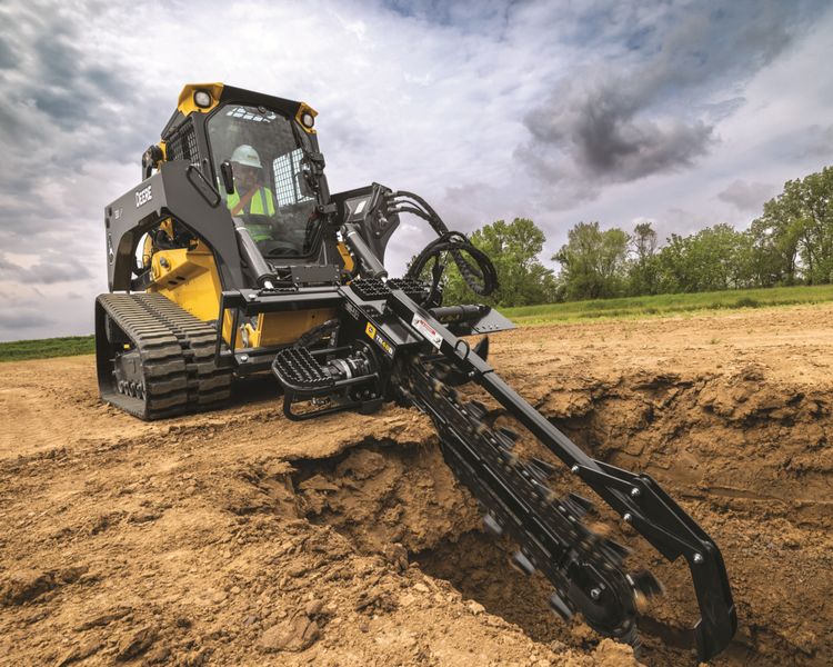 A compact track loader digs a hole.